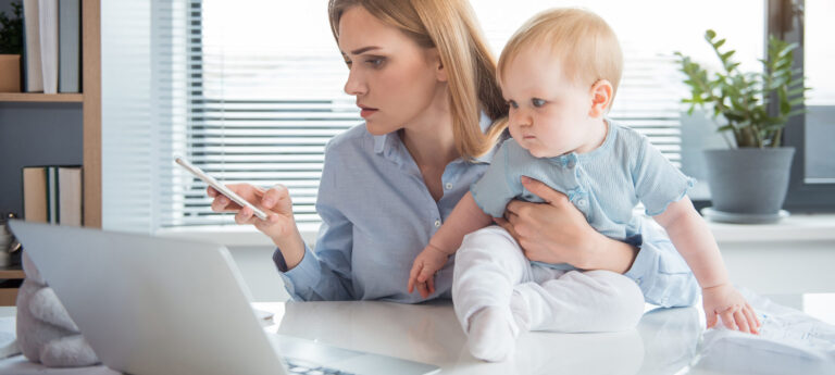 Busy mom in front of computer with baby