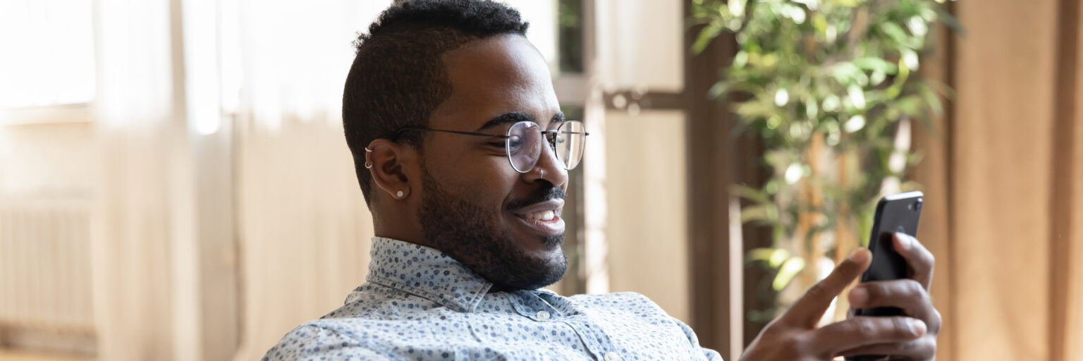 African man smiling at smart phone